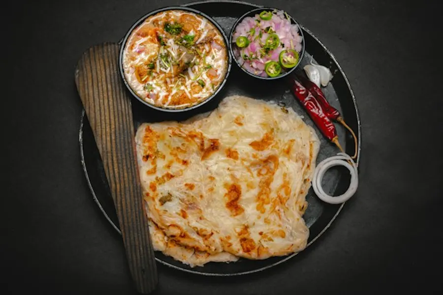 Aalu paratha served with pickle and curd.
