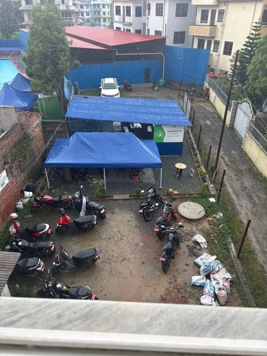 The courtyard with covered seating and motorbikes parked below.